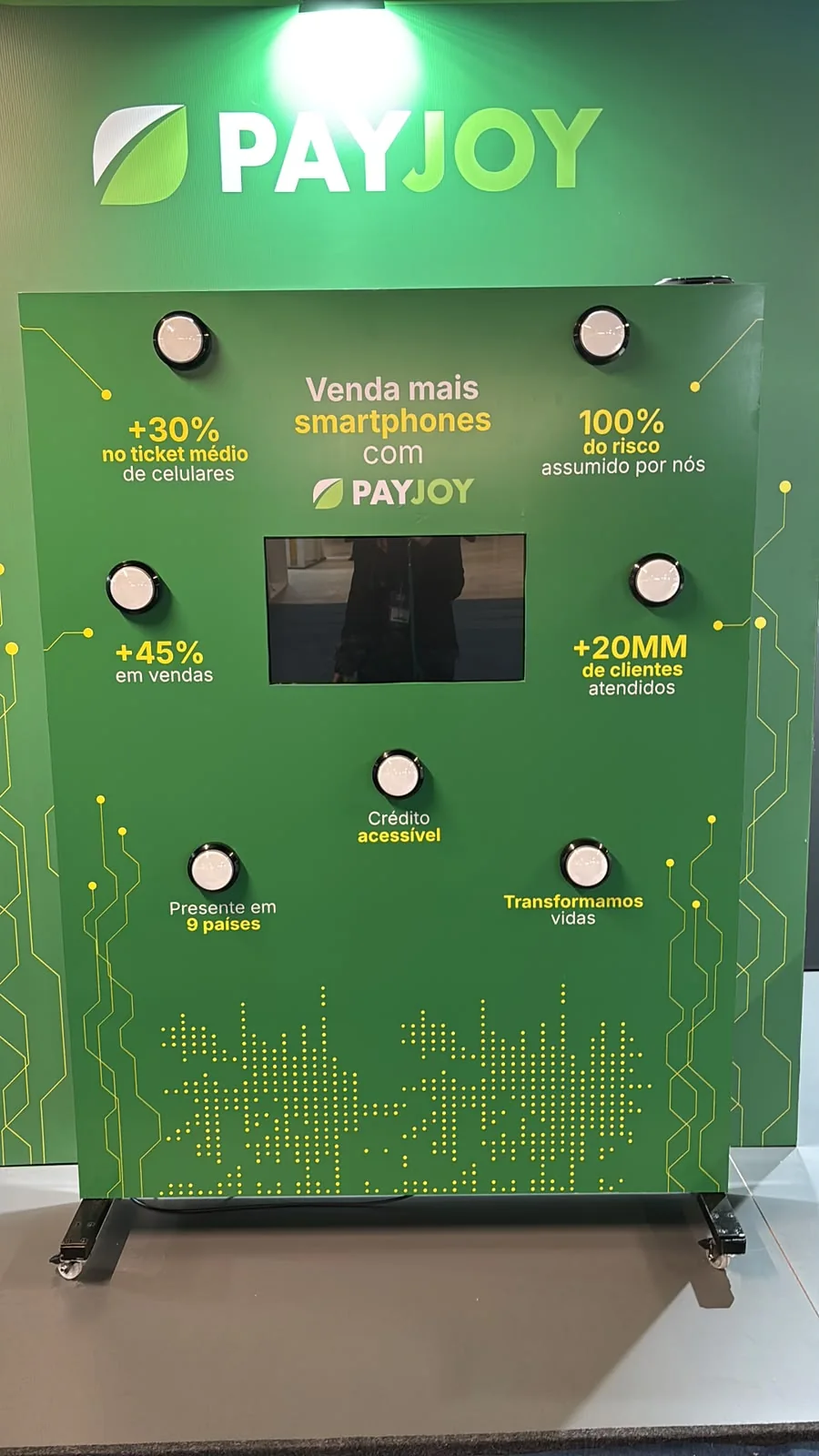 Batak interativo CZL no estande PayJoy, com pontos luminosos e tela no painel.
